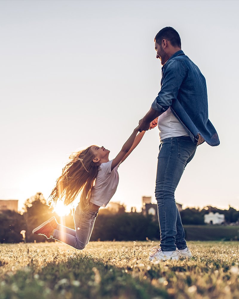 Father swinging his daughter in the air